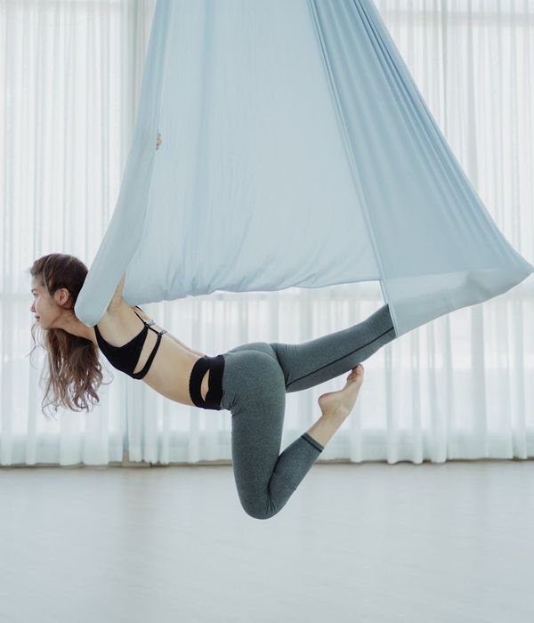 Woman performing a graceful yoga pose in a calm, focused setting.